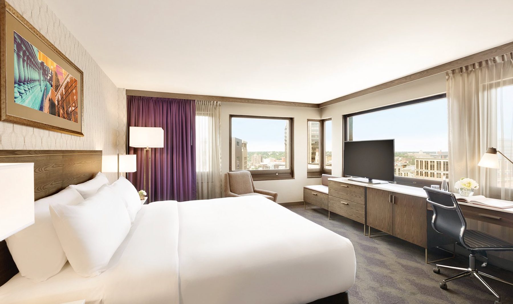 Hotel brand-conversion redevelopment — a renovated full-service guest room with a mid-century-modern interior